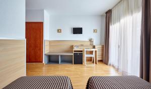 a hotel room with two beds and a desk at Gran Hotel Flamingo-Adults Only older 18 years old in Lloret de Mar
