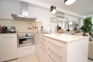 a kitchen with white cabinets and a stove top oven at Viva Sitges - Sitges View in Sitges