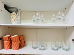 a row of glasses and shoes on a shelf at Apartament spatios in complex residential in Chişinău +12 photos