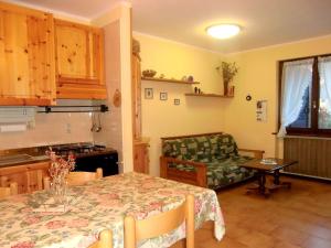 cocina y sala de estar con mesa y sofá en Stunning holiday home in Molina di Ledro near lake, en Molina di Ledro