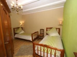 a bedroom with two beds and a chandelier at Spacious gîte for 6 persons in Hanviller, Mosel in Hanviller