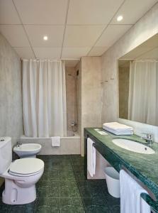 a bathroom with a toilet and a sink and a tub at Gran Hotel Flamingo-Adults Only older 18 years old in Lloret de Mar