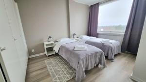 une chambre à l'hôpital avec deux lits et une fenêtre dans l'établissement Kotka Orange Apartments Tapuli, à Kotka