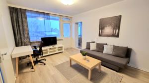 a living room with a couch and a desk and a piano at Kotka Orange Apartments Tapuli in Kotka