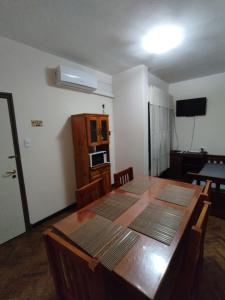 Habitación con mesa de madera, sillas y cocina. en Departamento Salvador - pleno centro-salta capital en Salta