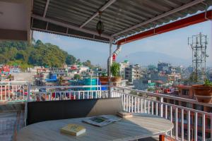 a table on a balcony with a view of a city at Lotus Apartment in Pokhara