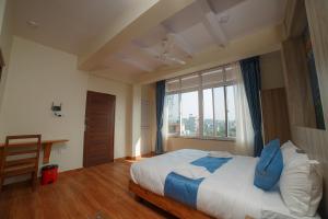 um quarto com uma cama grande e uma janela em Lotus Apartment em Pokhara