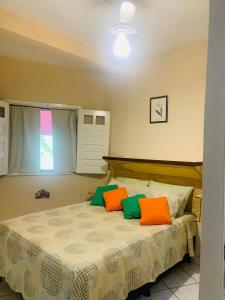 um quarto com uma cama com almofadas laranja e verde em Vila das Estrelas - Guesthouse em Lençóis