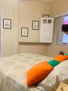 a bedroom with a bed with an orange pillow on it at Vila das Estrelas - Guesthouse in Lençóis