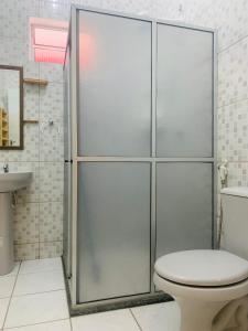 a bathroom with a shower with a toilet and a sink at Vila das Estrelas - Guesthouse in Lençóis