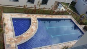 uma vista superior de uma piscina com azulejos azuis em Apartamento Bem Viver em Salvador