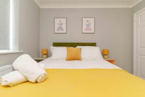 a bedroom with a large yellow bed with towels on it at Huntington House with Free off road parking in York
