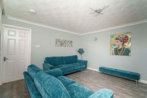 a living room with blue couches and a ceiling at Huntington House with Free off road parking in York