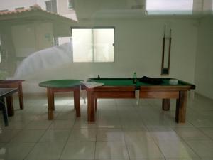 um quarto com uma mesa de bilhar e uma mesa em Apartamento Bem Viver em Salvador