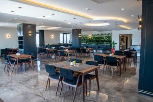 uma sala de jantar com mesas e cadeiras de madeira em Midyat Royal Hotel & Spa em Midyat