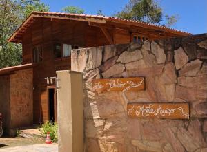 瓜拉米蘭加的住宿－Monte Suiço - Chalés para locação，房屋前的石墙