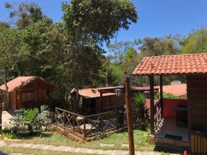 Monte Suiço - Chalés para locação في غواراميرانغا: منزل مع شرفة وسقف