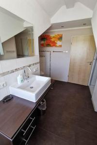 y baño con lavabo blanco y espejo. en Schwanensee Appartements, en Sommerach