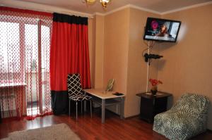 a living room with a table and a red curtain at Spacious apartment with balcony in Kremenchuk