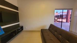 sala de estar con sofá y TV de pantalla plana en Casa Sossego, en Caldas Novas