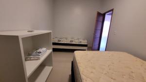 1 dormitorio con 2 camas en una habitación con espejo en Casa Sossego, en Caldas Novas