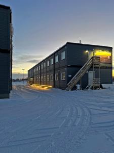 a building in the snow in front of a building at Kiruna City Room in Kiruna