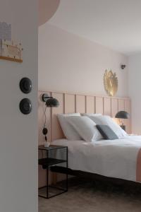 een slaapkamer met een groot wit bed en een tafel bij Hôtel Le Prieuré in Paray-le-Monial