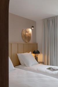 sypialnia z łóżkiem i lustrem na ścianie w obiekcie Hôtel Le Prieuré w mieście Paray-le-Monial