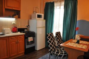 una pequeña cocina con nevera blanca y mesa en Spacious apartment with balcony, en Kremenchuk