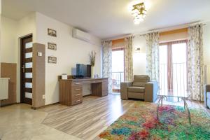 ein Wohnzimmer mit einem TV, einem Stuhl und einem Tisch in der Unterkunft VacationClub – Górna Resorts Apartament 1.33 in Szklarska Poręba