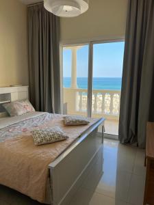 a bedroom with a bed with a view of the ocean at Royal Breeze view in Ras al Khaimah