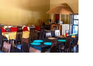 uma sala de jantar com mesas e cadeiras com assentos azuis em MSC Hotel Otjiwarongo em Otjiwarongo