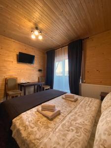 a bedroom with a bed with two towels on it at FORREST hotel in Bukovel