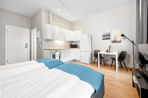 a white bedroom with a bed and a desk at Forenom Serviced Apartments Oslo Nobel in Oslo