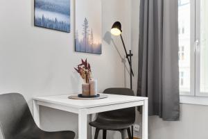 a white dining room table with chairs and a lamp at Forenom Serviced Apartments Oslo Nobel in Oslo