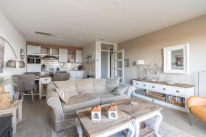 ein Wohnzimmer mit einem Sofa und einem Tisch in der Unterkunft Appartementencomplex Juliana 116 in De Koog
