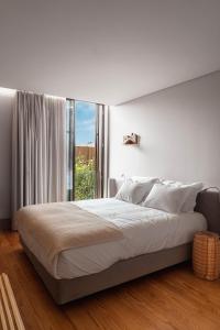 een slaapkamer met een groot bed en een groot raam bij Villã - Casas de Campo in Paredes
