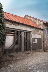 a stone building with a gate and a door at Villã - Casas de Campo in Paredes