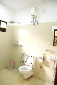 a bathroom with a toilet and a sink at Da Inn Home Stay in Garacherāma