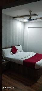 um quarto com uma cama com um cobertor vermelho em hotel shreenivas em Ahmedabad