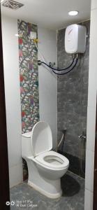 La salle de bains est pourvue de toilettes blanches. dans l'établissement hotel shreenivas, à Ahmedabad