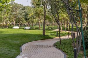 einen Backsteinweg in einem Park mit Bäumen in der Unterkunft STAY BY LATINEM Luxury 2BR Holiday Home CV A2509 near Burj Khalifa in Dubai