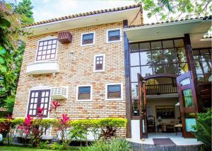 Casa de ladrillo con ventana grande en Pousada Casa da Praia Búzios, en Búzios