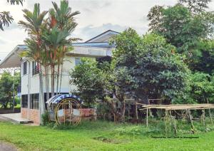 斗湖的住宿－Jalan Kuhara 300 mbps Detach Bungalow Family Fun BBQ Homestay，前面有树木的房子