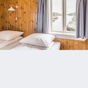 two beds in a room with a window at Portør Pensjonat in Kragerø