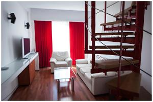 a living room with a spiral staircase and red curtains at Tania-Frankfurt Hotel in Bucharest