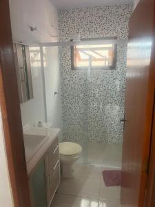 a bathroom with a toilet and a sink at Casa do Kélvio in Penha