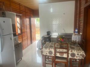 a small kitchen with a table and a refrigerator at Casa do Kélvio in Penha