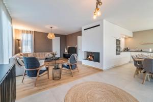 een woonkamer met een open haard en een tafel en stoelen bij Villa Sailing-large luxury house in quiet location in Nieuwpoort