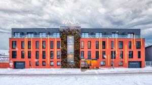 een rood gebouw met een bord in de sneeuw bij ABA Apartments in Olomouc